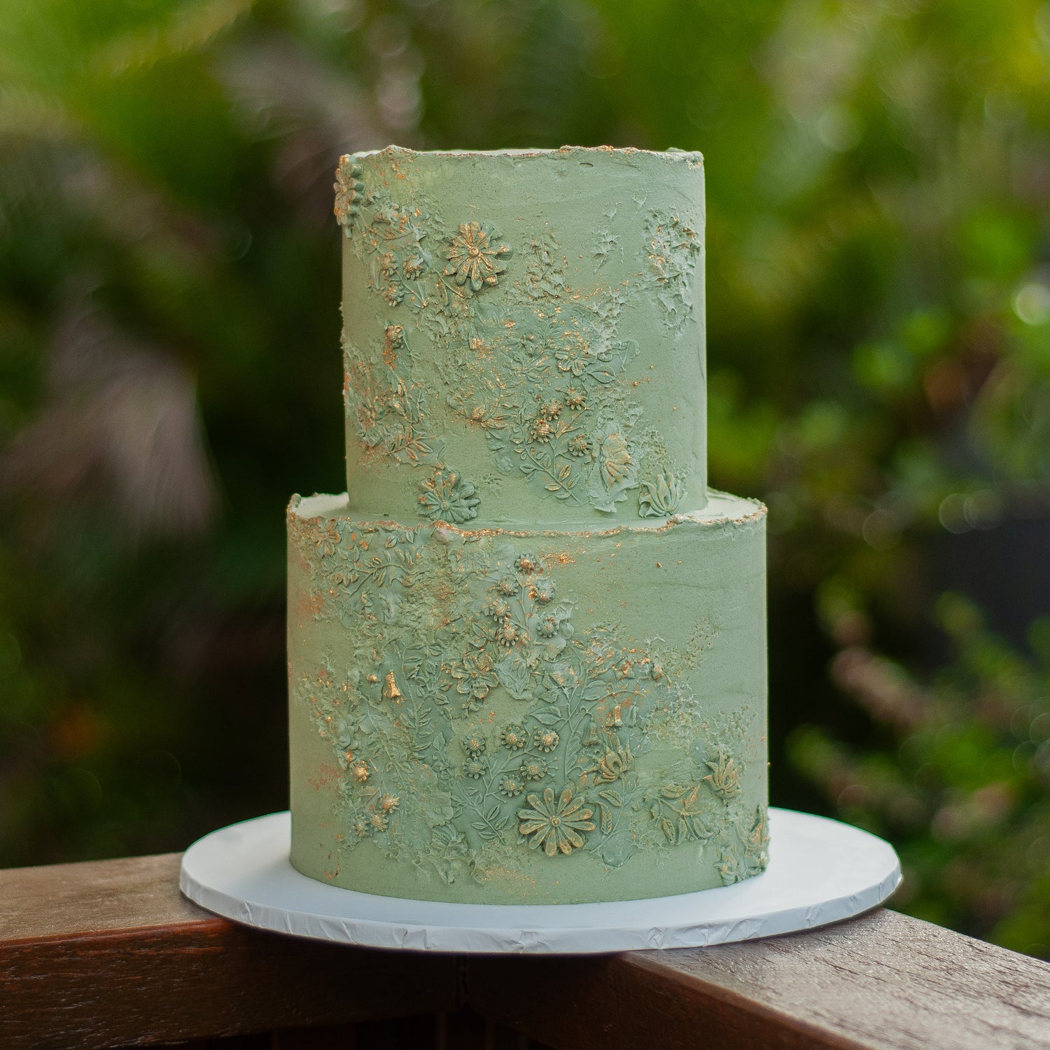 Two-tier wedding cake featuring textured green buttercream, gold accents, and delicate floral detailing, handcrafted for Brisbane weddings by Caldera.CAKING.